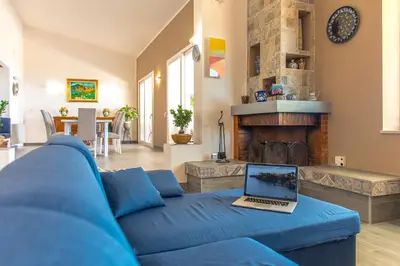 a blue couch in a living room with a laptop on it at La Villa di Sofia in Santa Flavia