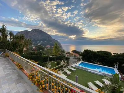 a balcony with a view of the ocean and a mountain at La Villa di Sofia in Santa Flavia