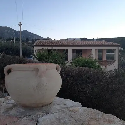 a large pot sitting on a rock in front of a house at Villa Noemy in Castellammare del Golfo