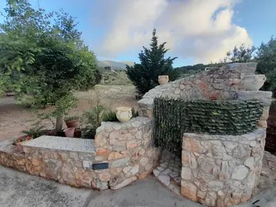 a stack of stone walls with trees in a field at Villa Noemy in Castellammare del Golfo