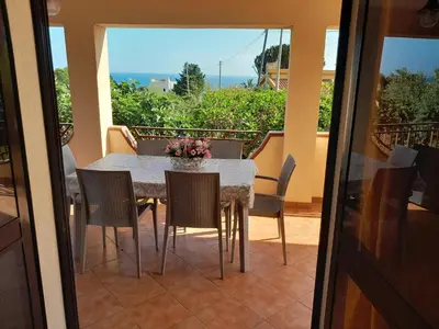 a dining room table and chairs on a balcony at Villa Noemy in Castellammare del Golfo