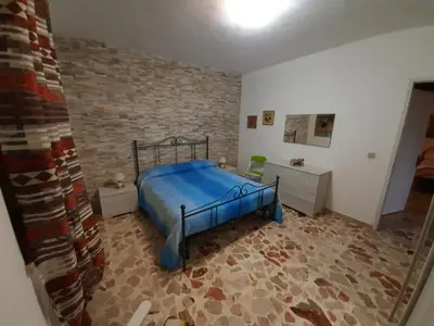 a bedroom with a bed and a brick wall at Villa Noemy in Castellammare del Golfo