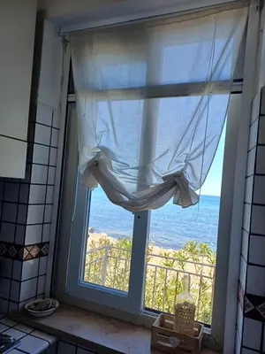 a kitchen window with a view of the ocean at Le due conchiglie in Carini