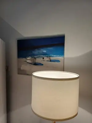 a white lamp in a room with a painting at Le due conchiglie in Carini