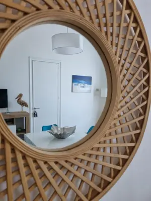 a round mirror with a table in front of a room at Le due conchiglie in Carini