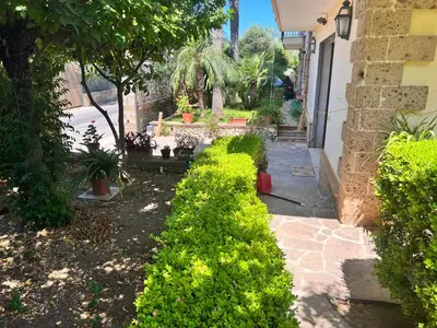 a row of bushes in a yard next to a house at IL Rustico di Giò in Carini