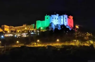 a building lit up in green and red at night at IL Rustico di Giò in Carini
