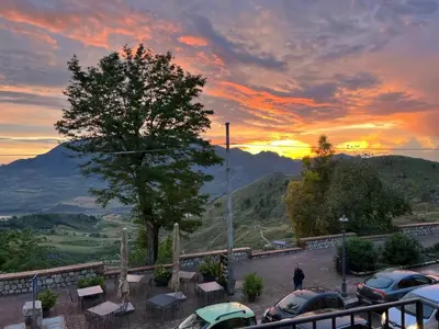 a man standing in a parking lot at sunset at IL DUCA HOUSE e HOLIDAY PRESTIGE in Caccamo