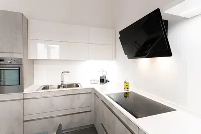 a kitchen with white cabinets and a tv on the wall at Casa di Dada - statua in Palermo