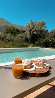 a tray of pastries on a table next to a pool at Marosa Casa Vacanze in Torretta