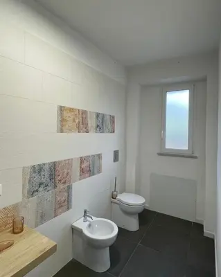 a white bathroom with a toilet and a sink at Marosa Casa Vacanze in Torretta