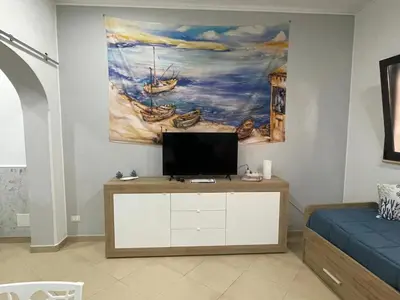 a living room with a tv and a painting on the wall at Domus Rosaliae - Casa Vacanze in Palermo