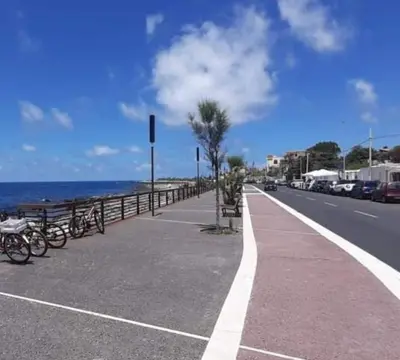 a street with bikes parked next to the ocean at Domus Rosaliae - Casa Vacanze in Palermo