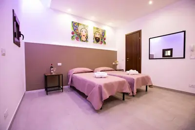 a room with two beds with pink blankets at La Domus di Segesta 
