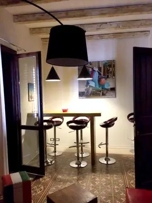 a dining room with a table and stools at Spacious apartment with sea view in Castellammare del Golfo in Castellammare del Golfo
