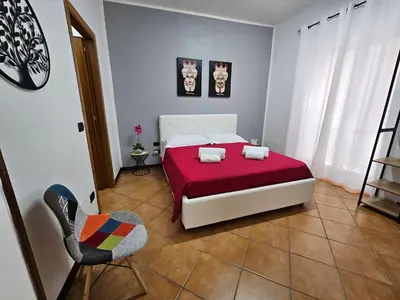 a bedroom with a bed and a chair in it at LA CASA DI VIOLA in Palermo