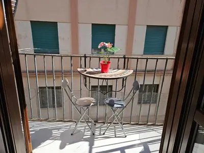 a table and chairs on a balcony with a potted plant at LA CASA DI VIOLA in Palermo