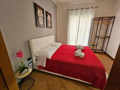 a bedroom with a red bed with a teddy bear on it at LA CASA DI VIOLA in Palermo