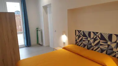a bedroom with a bed with an orange bedspread at Mami Holiday House in Castellammare del Golfo