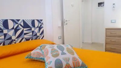 a bedroom with an orange bed with a pillow on it at Mami Holiday House in Castellammare del Golfo