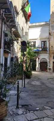 a street sign in front of a building with a flag at Le Casette in Palermo