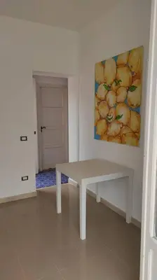 a white room with a bench and a painting of apples at VILLA CHIARA 200 MT DA MARE SPIAGGIA LIBERA SABBIA in Capaci