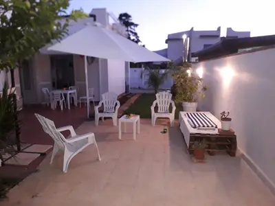 a patio with white chairs and a table and an umbrella at VILLA CHIARA 200 MT DA MARE SPIAGGIA LIBERA SABBIA in Capaci