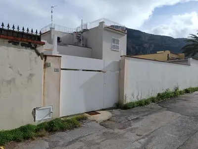 a white building with a gate and a fence at VILLA CHIARA 200 MT DA MARE SPIAGGIA LIBERA SABBIA in Capaci