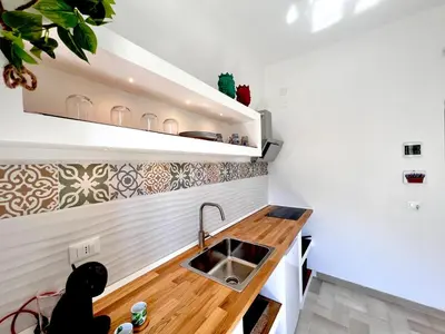 a small kitchen with a wooden counter and a sink at Villa di Nera Apartments in Palermo