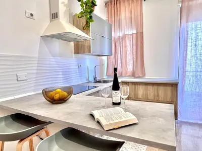 a kitchen with a table with a bottle of wine and a book at Villa di Nera Apartments in Palermo