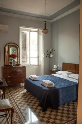 a bedroom with a bed with two towels on it at Battisti 18 Vintage Rooms in Palermo