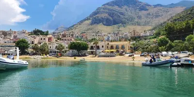 a group of boats in a body of water with a town at Hotel Cala Marina in Castellammare del Golfo