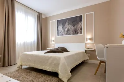 a bedroom with a bed and a painting on the wall at Le Palme in Terrasini