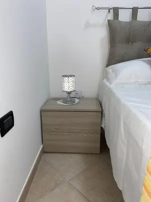 a lamp on a night stand next to a bed at Holiday mode EVA in Partinico