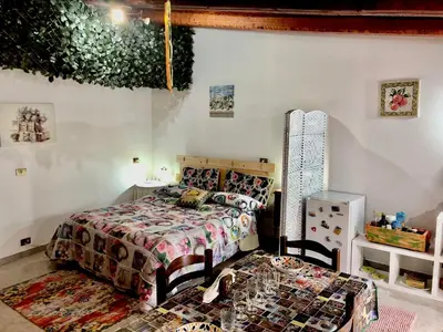 a bedroom with a bed and a table and a chair at Appartamento Green Room in Palermo