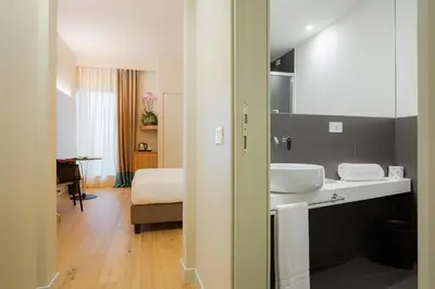 a bathroom with a sink and a bed in a room at Hotel Politeama in Palermo