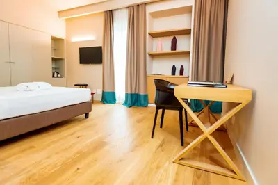 a bedroom with a bed and a desk with a laptop at Hotel Politeama in Palermo