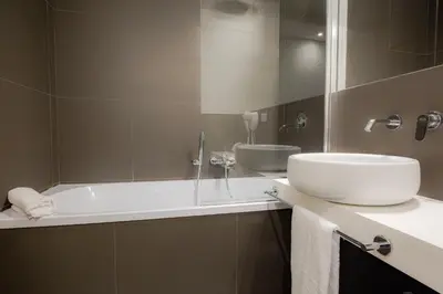 a bathroom with a sink and a bath tub at Hotel Politeama in Palermo