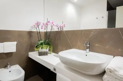 a bathroom with a white sink and a toilet at Hotel Politeama in Palermo