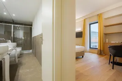 a bathroom with a tub and a sink and a bed at Hotel Politeama in Palermo