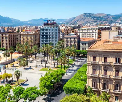 an aerial view of a city with palm trees and buildings at Hotel Politeama in Palermo