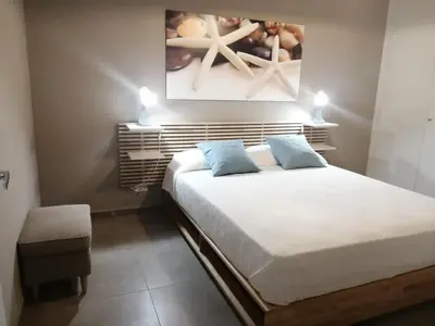 a bedroom with a large white bed with blue pillows at Appartamento Corallo in San Vito lo Capo