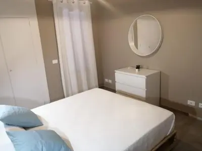 a bedroom with a white bed and a mirror at Appartamento Corallo in San Vito lo Capo
