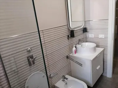 a bathroom with a sink and a toilet and a mirror at Appartamento Corallo in San Vito lo Capo