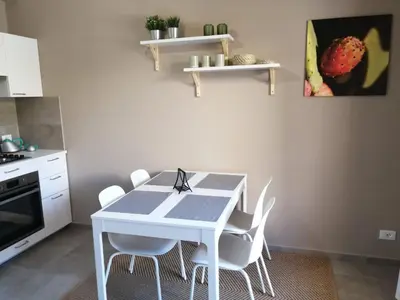 a kitchen with a white table and white chairs at Appartamento Corallo in San Vito lo Capo