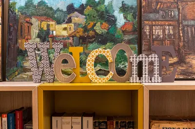 a sign on top of a book shelf with books at La Paperella Blu Apartment in Termini Imerese