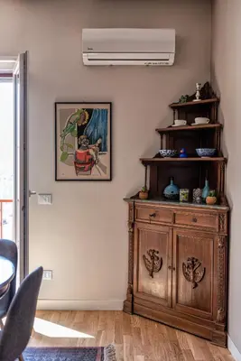 a living room with a wooden cabinet and a fan at La Paperella Blu Apartment in Termini Imerese