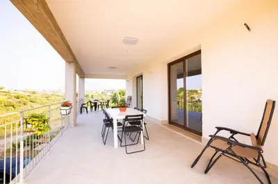 a patio with a table and chairs on a balcony at Villa Arianna, il piacere di vivere nella natura. in Alcamo