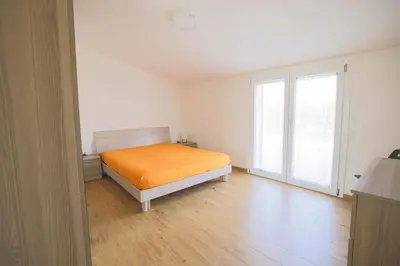 a bedroom with a bed with an orange blanket at Villa Arianna, il piacere di vivere nella natura. in Alcamo
