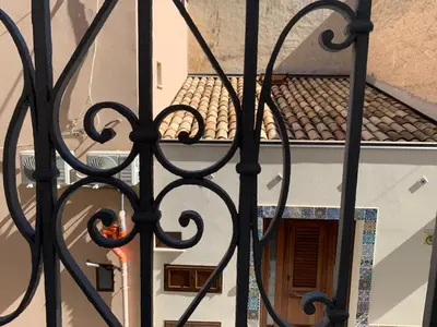 an iron gate with a view of a building at Casa Katrin & Casa Brigida in Castellammare del Golfo